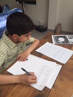 A boy doing extensive handwritten homework